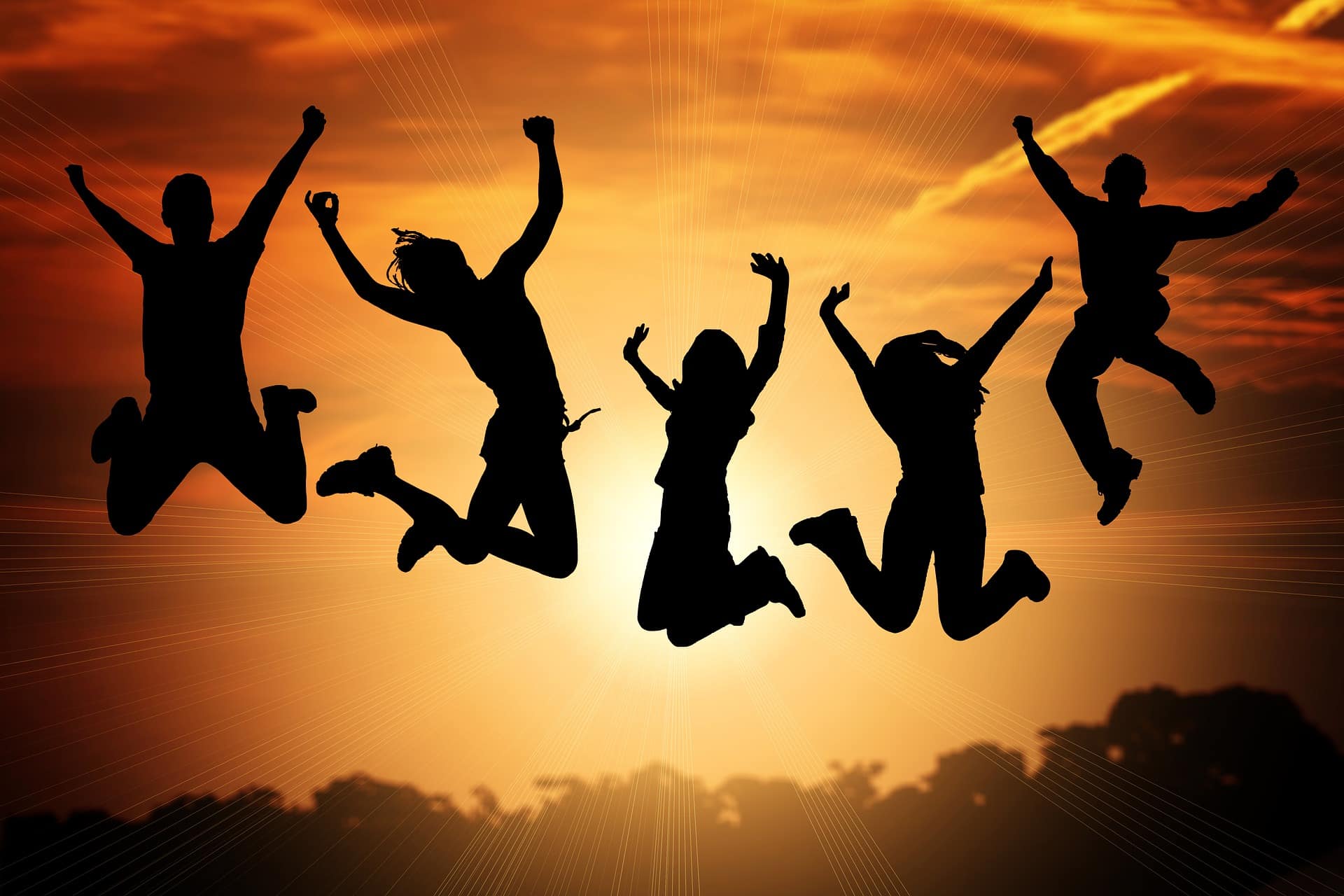 Silhouettes of 5 people jumping for joy celebrating success