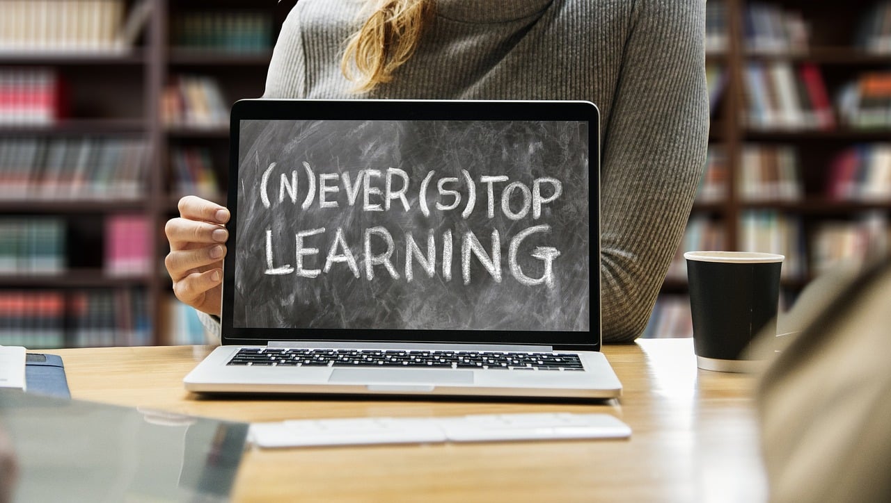 the words "never stop learning" displayed on a laptop