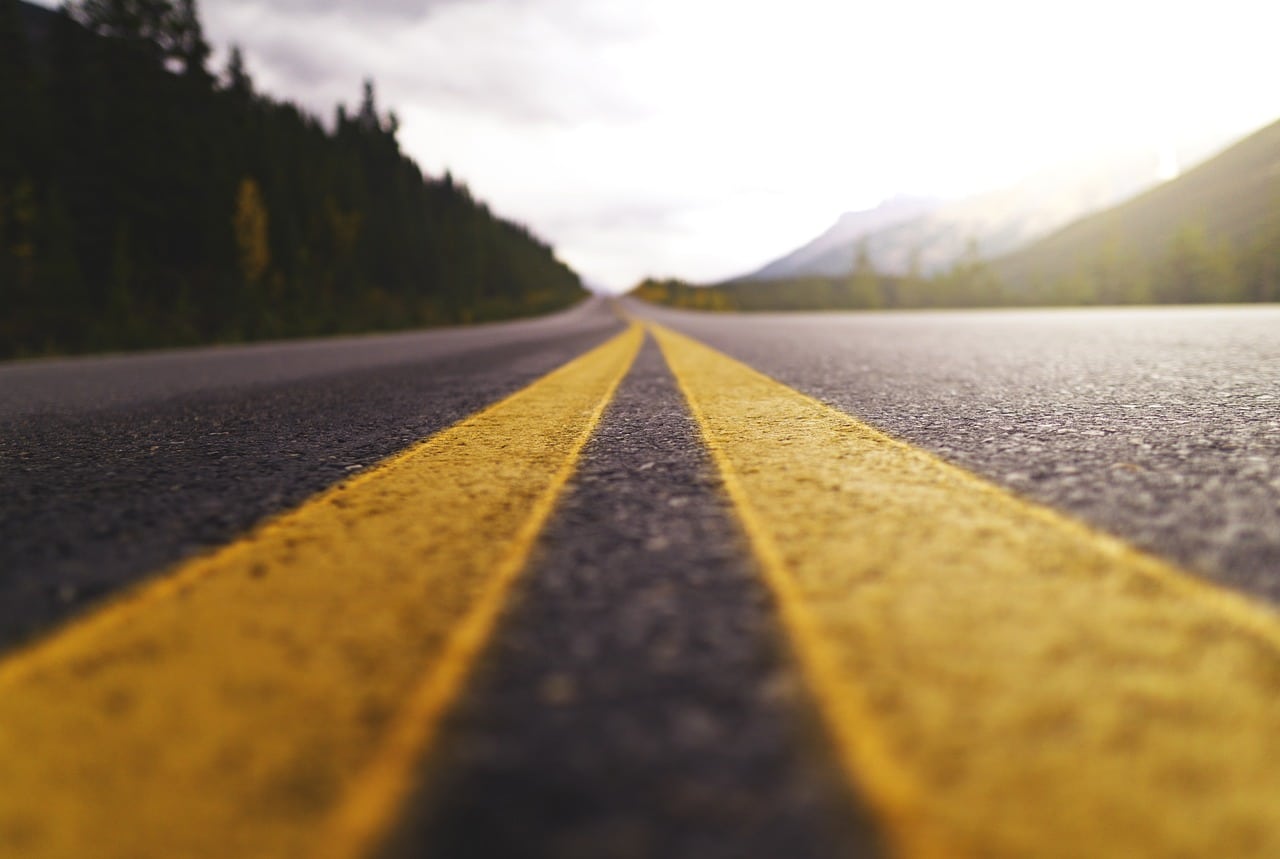 An image taken in the middle of the road with the road extending to the horizon