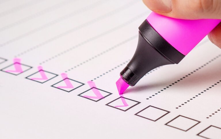 Checking off boxes on a checklist with a pink highlighter